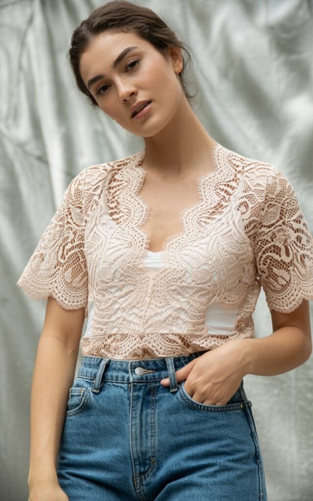 A natural-looking young woman wearing a lace top styled with mom jeans instead of a basic tee. Theme Lace Tops and Outfits