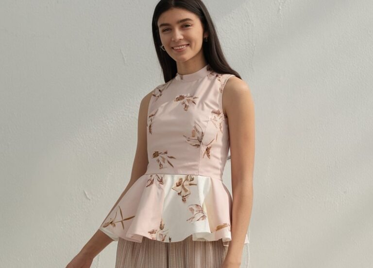 A natural-looking young woman wearing a sleeveless peplum top paired with wide-leg pants. Theme girly summer outfits