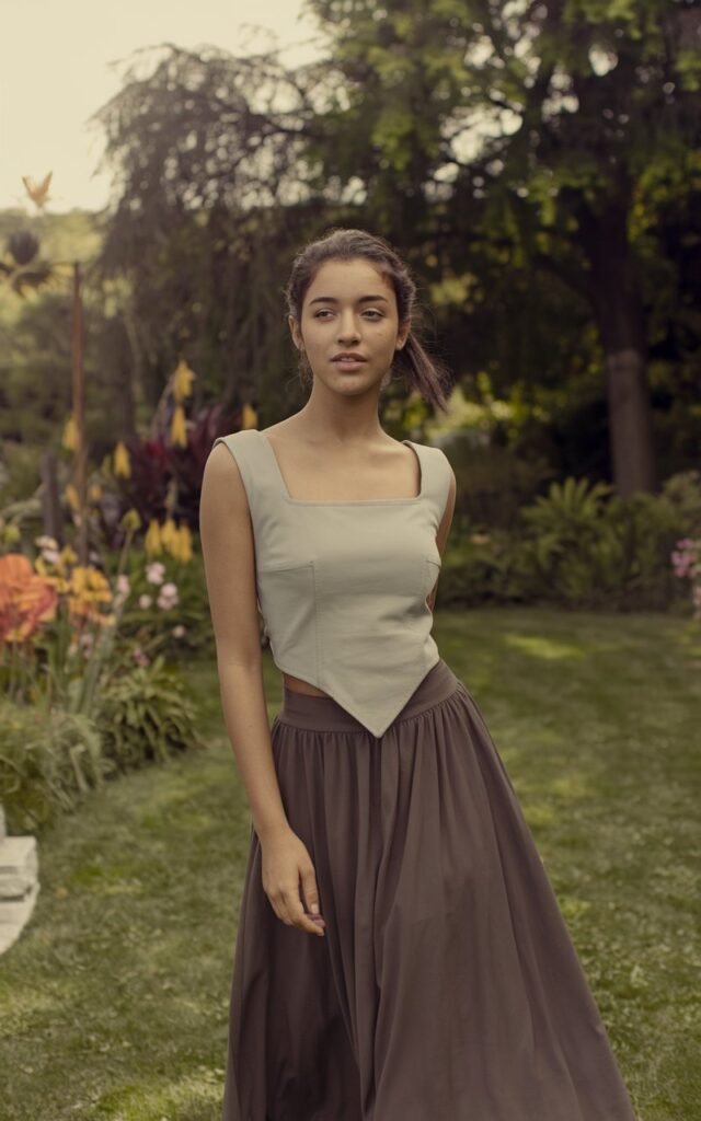 A natural-looking young woman wearing a square-neck top styled with a flowy A-line skirt. Theme girly summer outfits