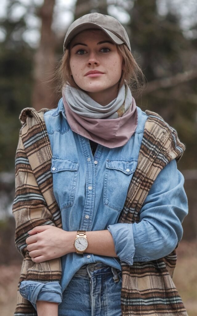 A natural-looking young woman wearing simple casual clothing styled with low-profile sneakers for an effortless look. Theme tomboy outfits