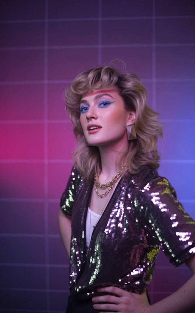 A natural-looking young woman wearing a sequined top for night-out glam. Theme 80s outfits
