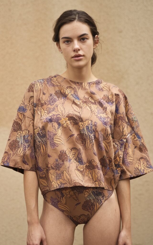 A natural-looking young woman wearing an oversized top paired with tight bottoms. Theme 80s outfits