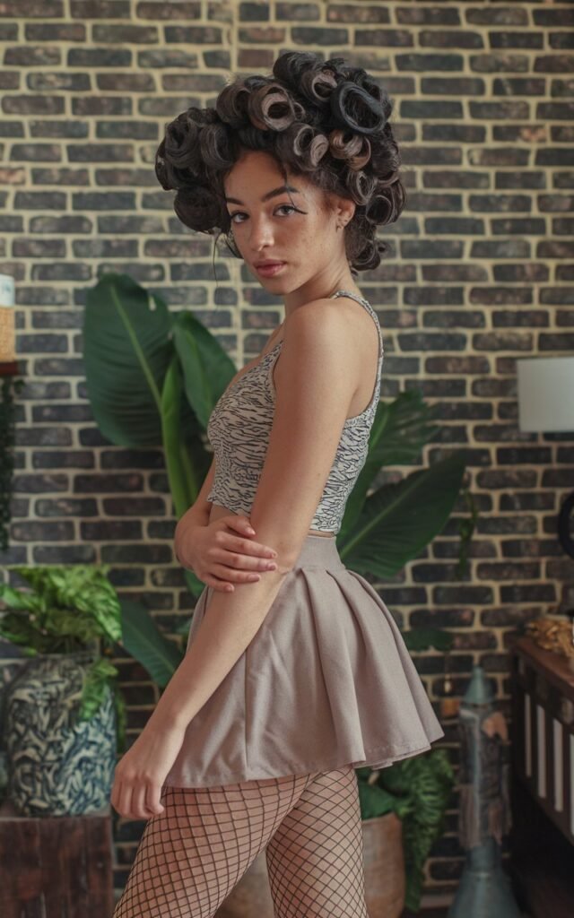 A natural-looking young woman wearing fishnet tights paired with a mini skirt. Theme 80s outfits