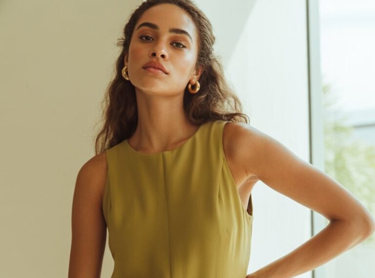 A natural-looking young woman wearing a chic jumpsuit styled with minimal accessories. Theme lookbook outfits