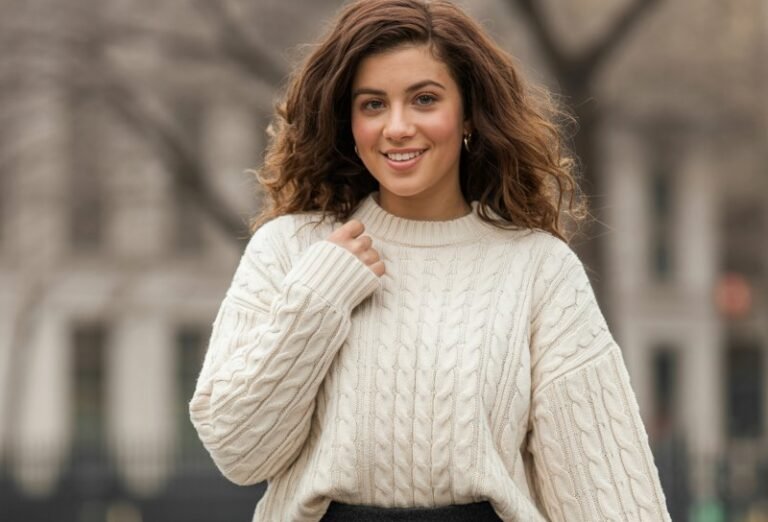 A natural-looking young woman wearing a fitted mini skirt contrasted with an oversized cozy sweater. Theme mini skirt outfit winter
