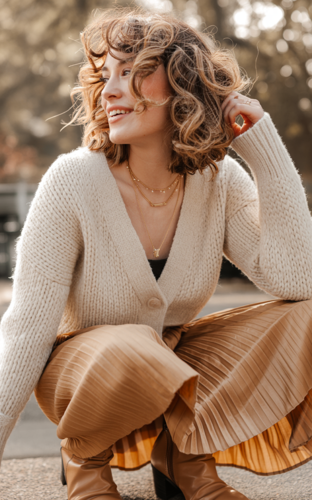 Wear a textured cardigan with a pleated midi skirt.